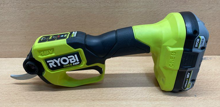 sécateur ryobi one 18v posé sur une table